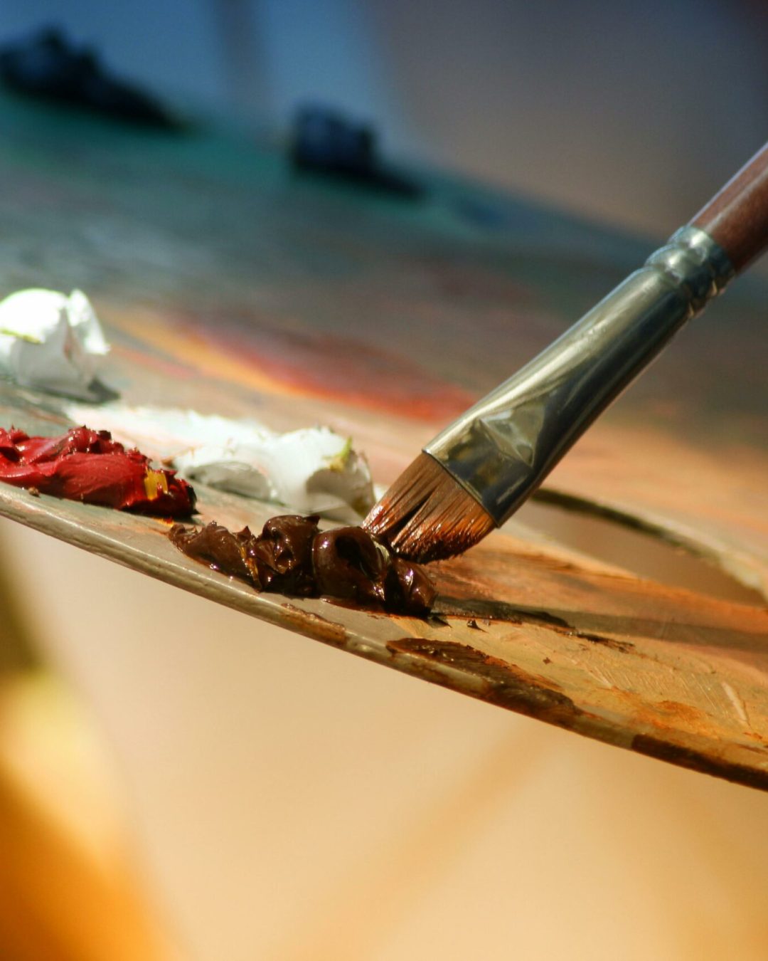 Vibrant artist palette with paint and brush creating colorful artwork.